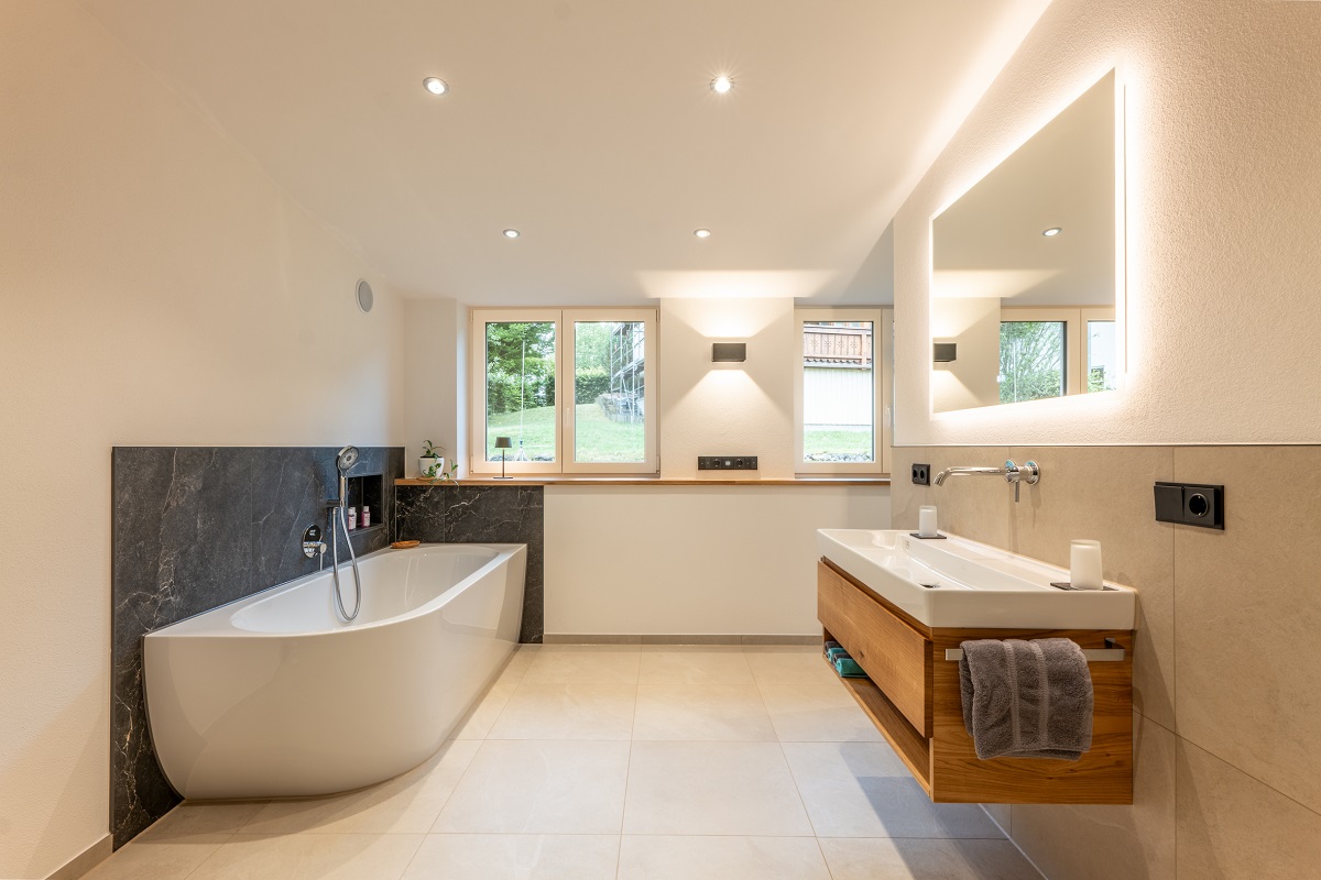 Modernisiertes Bad mit freistehender Wanne, Fensterfront und Waschbecken