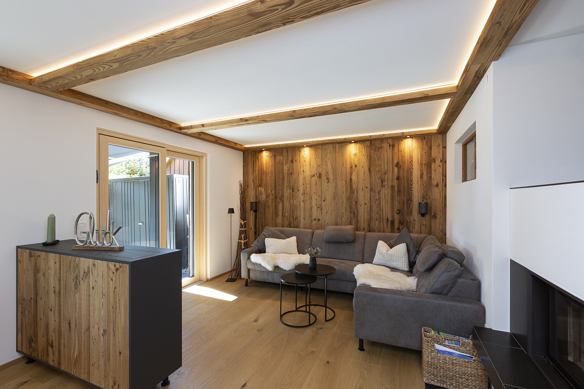 Offener Wohnbereich mit Dachschräge, Holzbalken und Holzfussboden